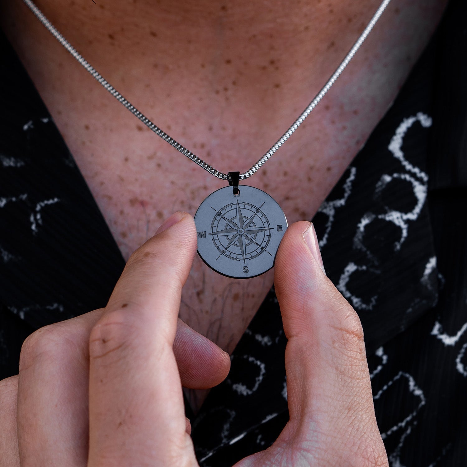 Man Holding Compass Black Diamond Pendant That is Around His Neck | Solid Black Diamond Pendant for Men | Black Diamond Pendants | Collections | Elysium Black Diamond