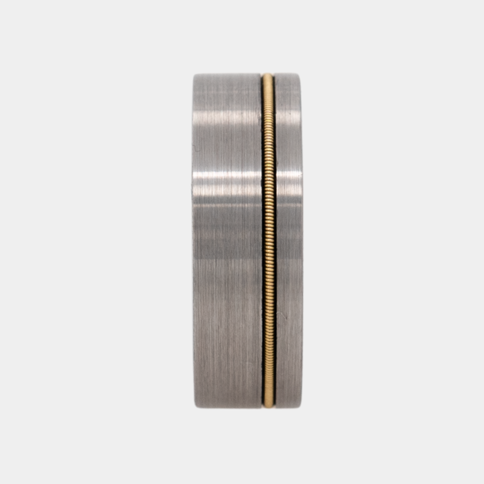 Orpheus ring – Brushed Silver Tungsten with Gold Guitar String Inlay from The Hustler Collection. Ring standing upright to show profile and thickness.
