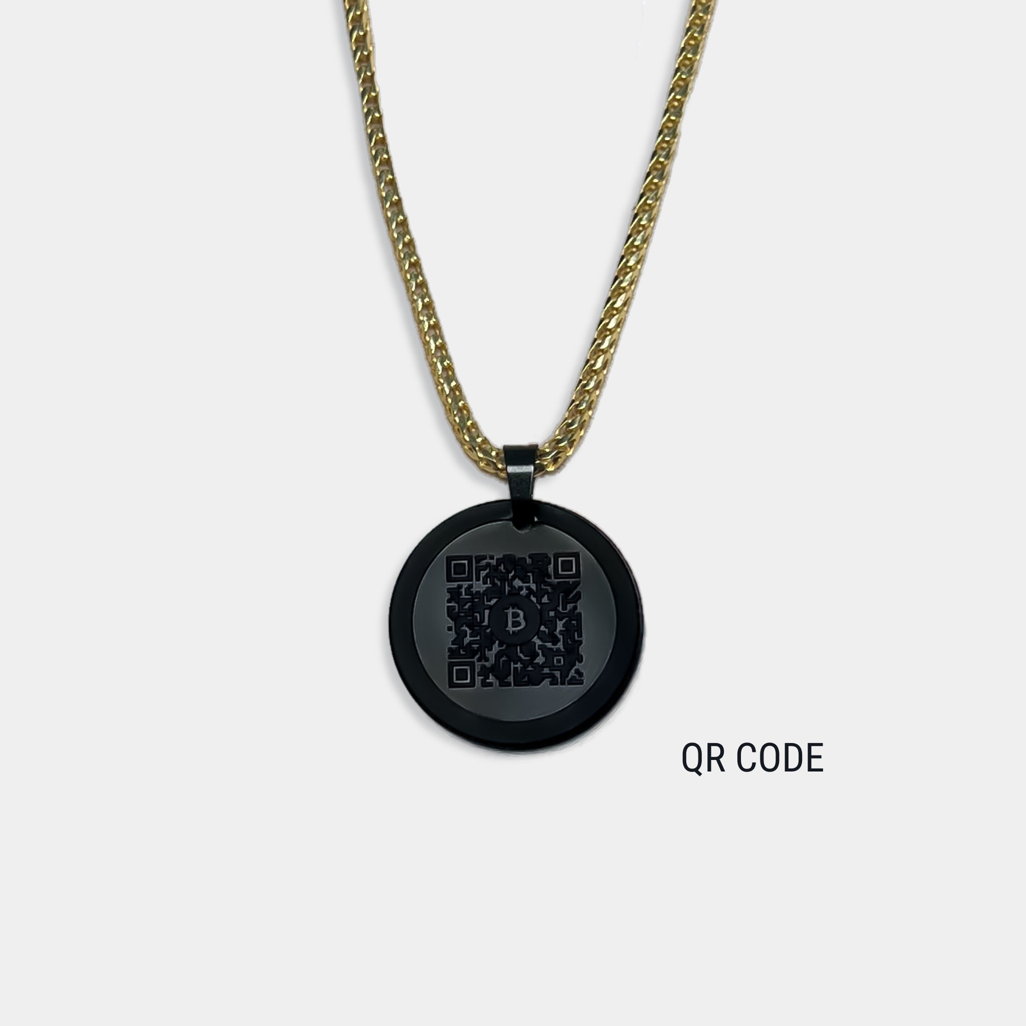 Photo of round solid black diamond pendant with qr code engraved, attached to gold chain