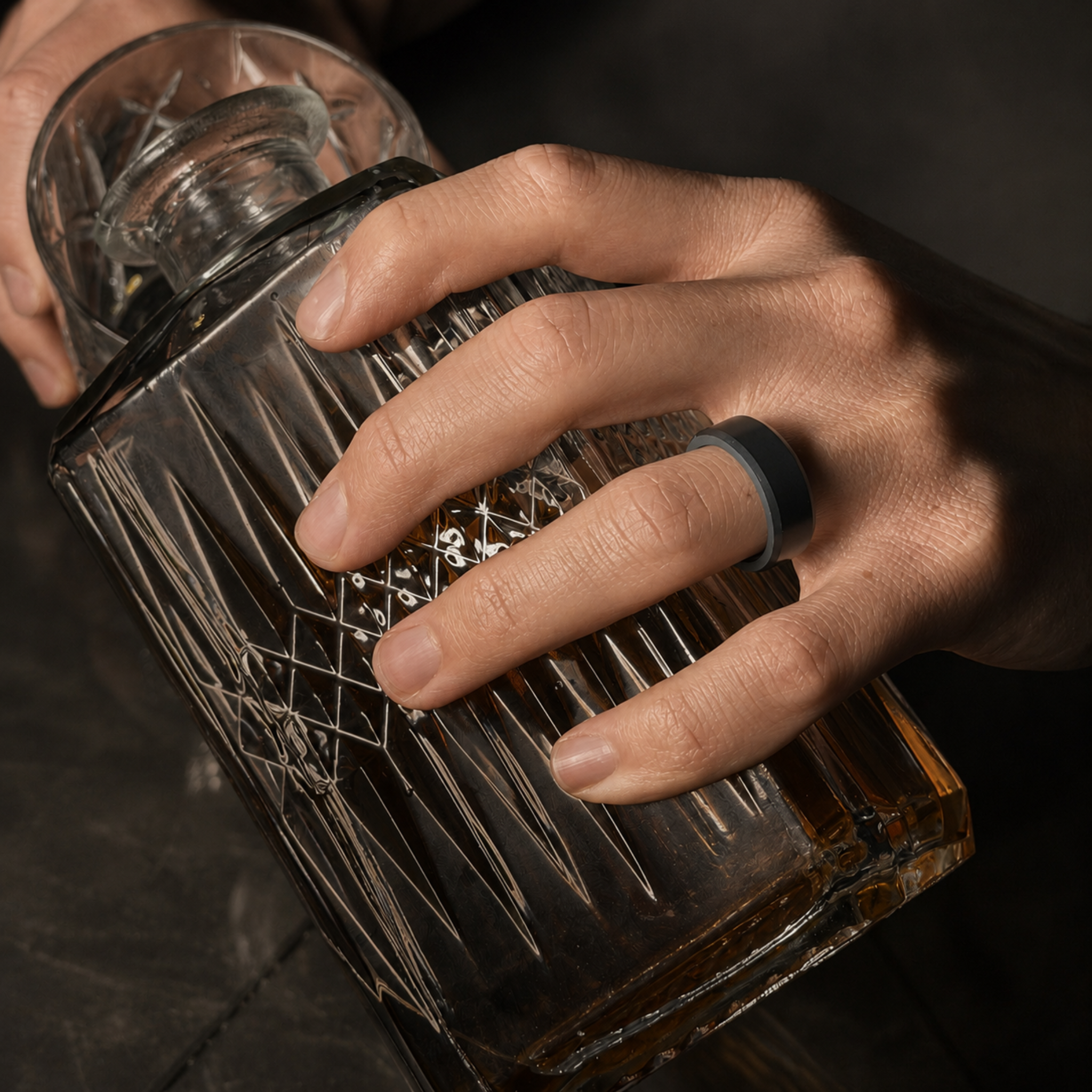 ARES solid black diamond wedding band in 8mm polished finish, worn on hand beside a whiskey glass